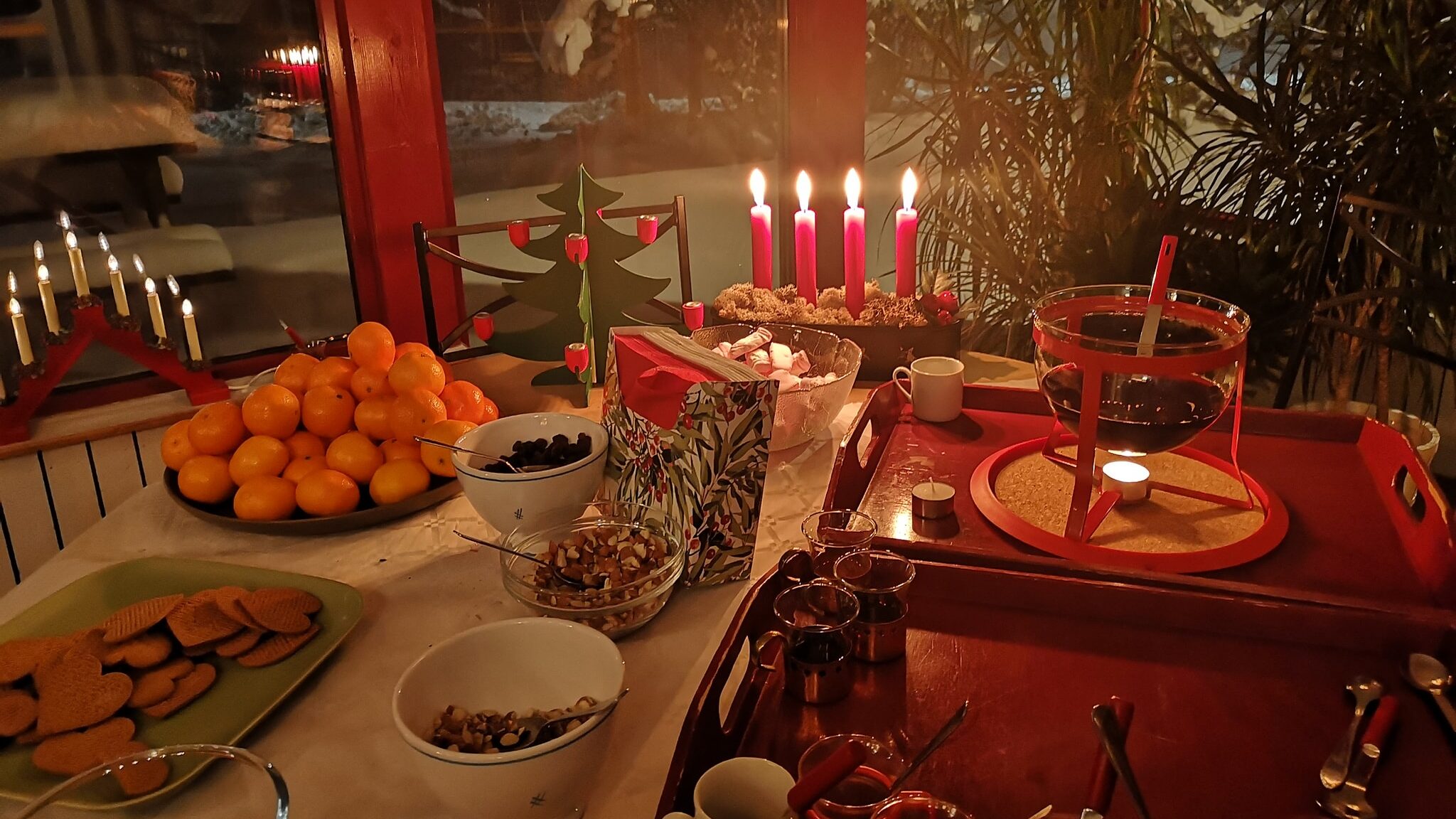 Bild på ett julbord med mat och tända ljus