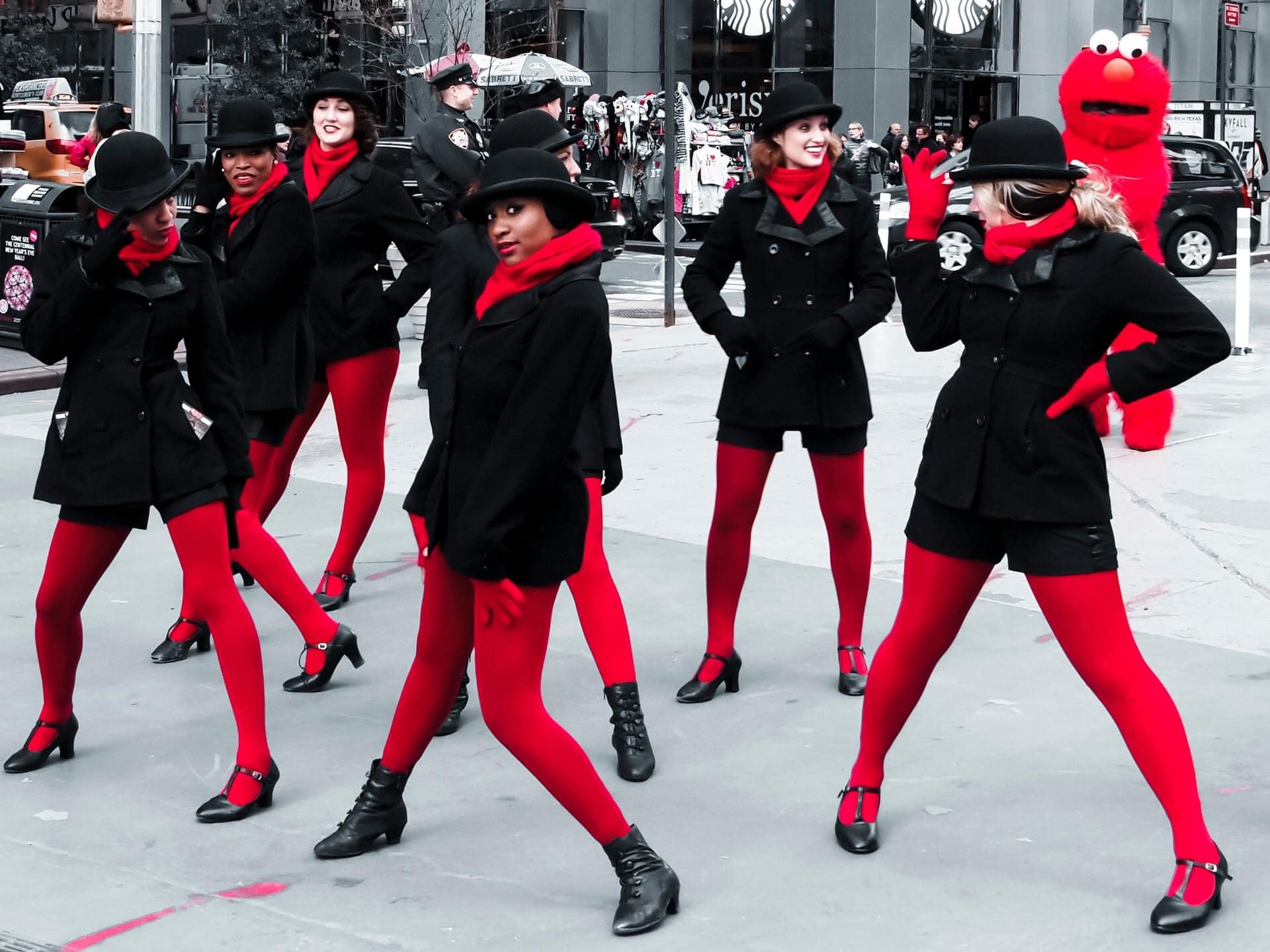 Gatubild som visar kvinnor klädda i svart och rött från en parad